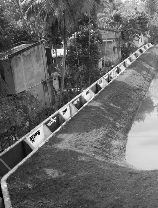 The boundary wall that cordons off the drinking water pond from the adjoining village settlement in arsenic-affected Madhusudankati, North 24 parganas district, West Bengal
